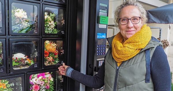 Elke Schmalzried ist stolz auf ihre neue „Mitarbeiterin“, den Blumenautomaten vor ihrem Laden. Foto: Holm Wolschendorf