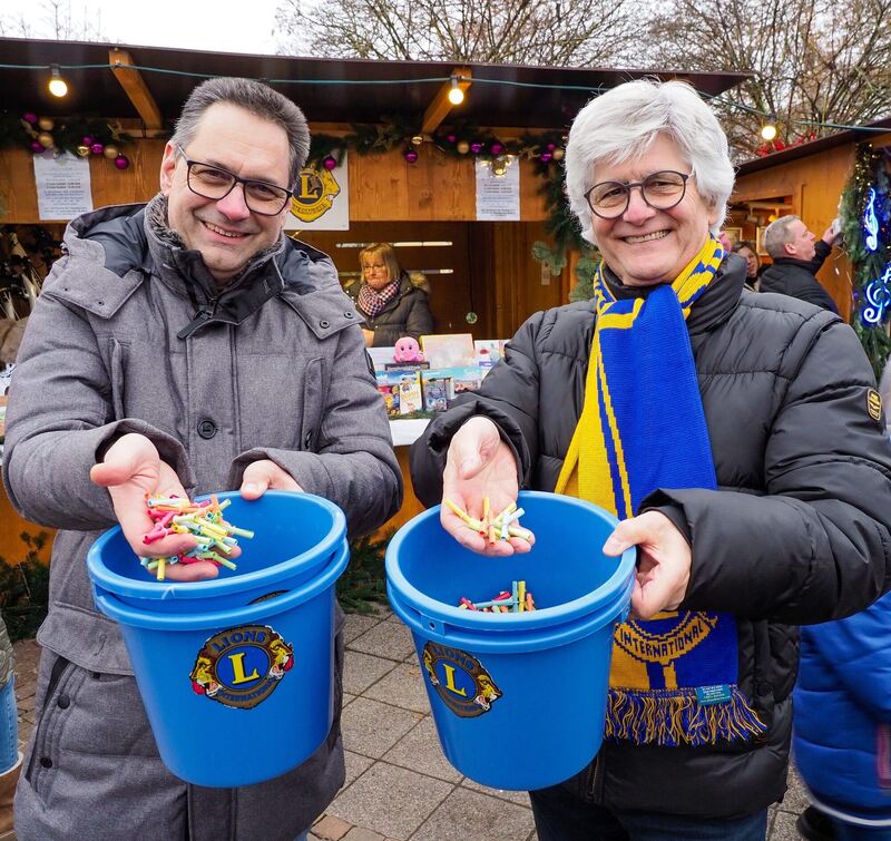 Thomas Nytz und Günter Broischmann von den Lions verkaufen Lose beim Kornwestheimer Weihnachtsmarkt. Foto: Holm Wolschendorf