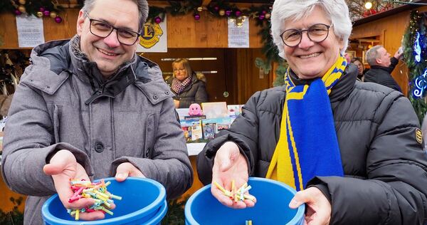 Thomas Nytz und Günter Broischmann von den Lions verkaufen Lose beim Kornwestheimer Weihnachtsmarkt. Foto: Holm Wolschendorf