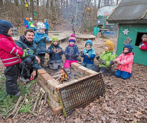 Einige Kinder fachen mit Erzieher Valentin das Feuer an. Fotos: Holm Wolschendorf