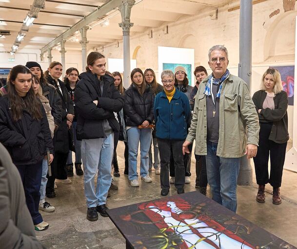Professor Thomas Bickelhaupt erklärt den Studierenden welche, Beziehungen er mit den Gemälden durch die Hängung herstellen wollte. Foto: Andreas Becker