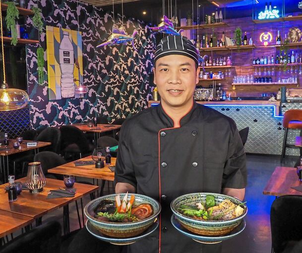 Chefkoch Huang präsentiert auf dem Foto zwei verschiedene Ramensuppen. Foto: Holm Wolschendorf