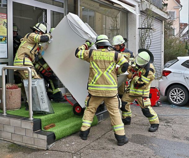 Feuerwehrleute bringen den Trockner aus dem Geschäft. Foto: KS-Images.de/Andreas Rometsch