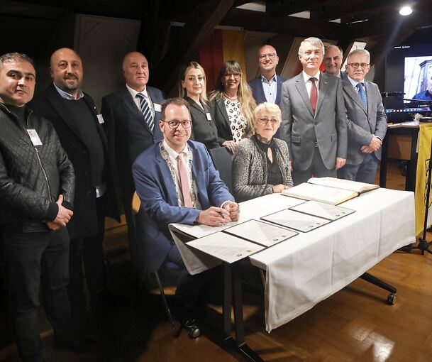 Bürgermeister Jan Trost und Emriye Takir, die Frau seines türkischen Amtskollegen, präsentieren die Urkunden. Dahinter Mitglieder der Delegation aus der Türkei und aus Marbach. Foto: Ramona Theiss