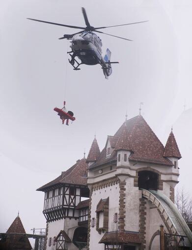 Ein Höhenretter hängt über der Achterbahn am Seil des Hubschraubers. Foto: Alfred Drossel