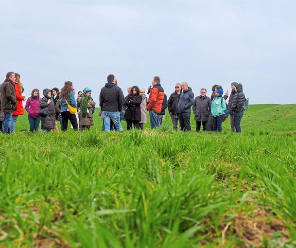 Joachim Bay (rote Jacke) führt in Erdmannhausen über die Felder seines Biohofs. Foto: Holm Wolschendorf