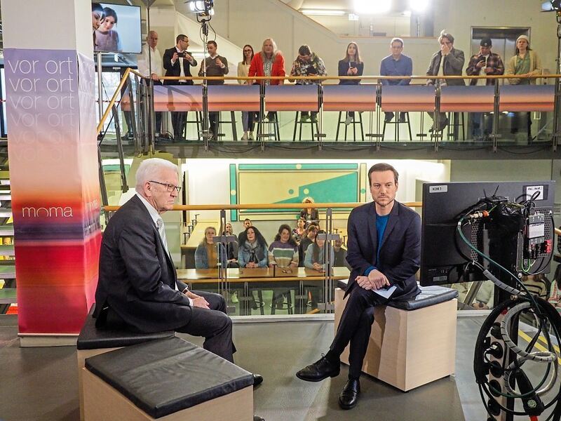 Ministerpräsident Winfried Kretschmann steht Moderator Andreas Wunn Rede und Antwort.
