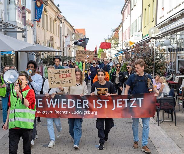 Die Demonstration führt quer durch die Innenstadt, vorbei an Cafés und Ladenzeilen.