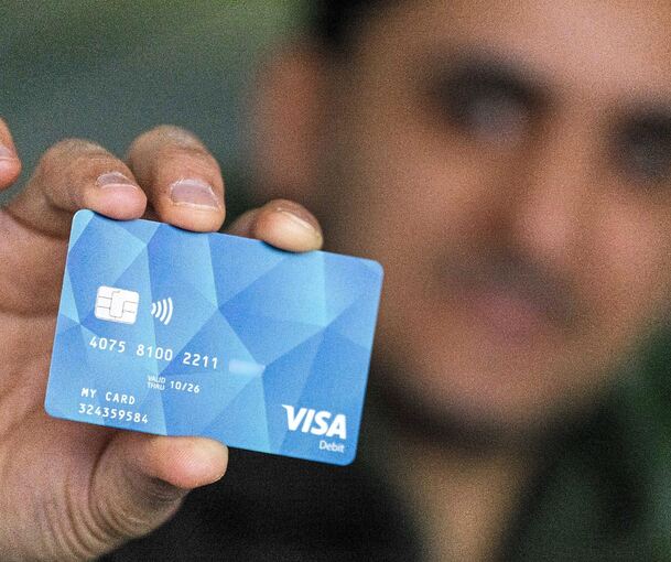 Ein Mann hält eine Bezahlkarte für Geflüchtete in der Hand: Im Kreis Ludwigsburg könnte die Umsetzung gegen Ende des Jahres erfolgen.