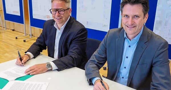 Der Freiberger Bürgermeister Dirk Schaible (rechts) und Heico Zirkel von der Stuttgarter Gustav Epple Bauunternehmung unterzeichnen im Prisma den Vertrag für Planung und Bau der neuen Kasteneckschule.