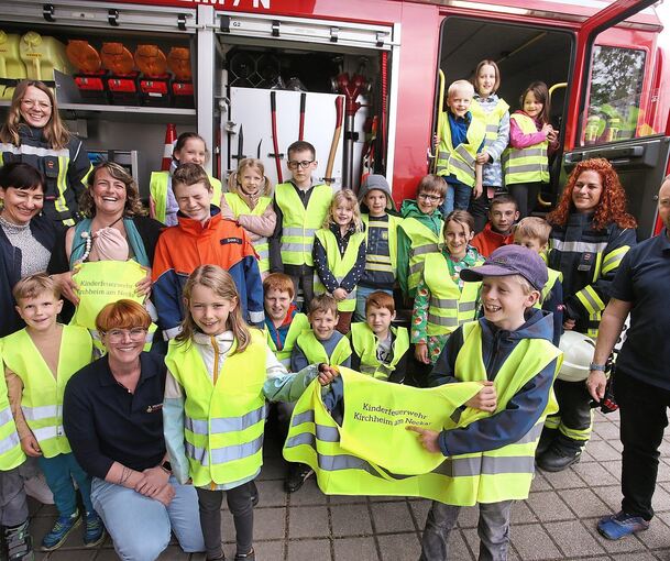Kommandant Christian Scherb (rechts) mit der Kirchheimer Kinderfeuerwehr, Links vorne kniend, die Leiterin der Kindergruppen Stephanie Sojka. Beim ihrem vergangenen Treffen haben die Kinder den Polizeiposten Kirchheim besucht.