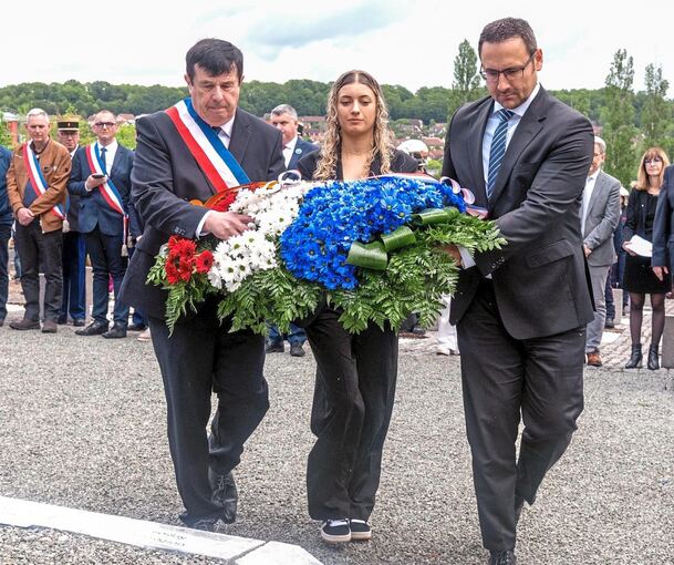 Eric Houlley, Bürgermeister von Aspergs Partnerstadt Lure, Gymnasiastin Loreley Dewulf, die ein Gedicht von Heinrich Heine über die deutsch-französische Freundschaft vorgetragen hatte, und Asperg Rathauschef Christian Eiberger mit Trikolore-Kranz bei