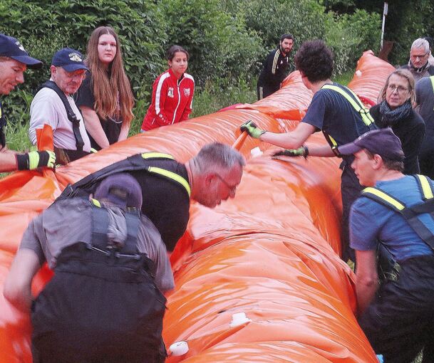 Hessigheimer Bürger packen mit an, als der mobile Damm aufgebaut wird.
