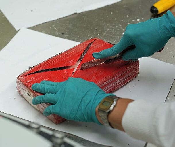 Ein Ermittler schneidet ein Päckchen sichergestelltes Kokain auf (Symbolbild).