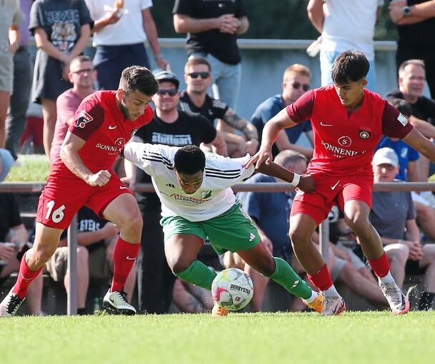 Die Großaspacher Marius Kunde (links) und Janis Gesell nehmen den Heimerdinger Angreifer Ivanilson Guerra Matias in die Zange.