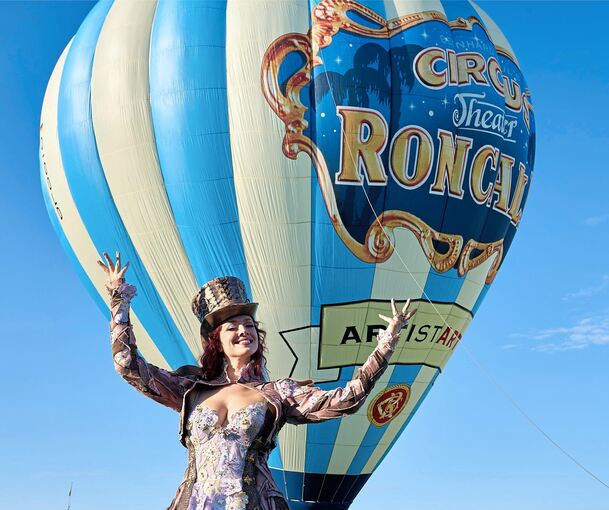 Illusionistin Alexandra posiert vor dem Heißluftballon, bevor er zu seiner Jungfernfahrt startet.