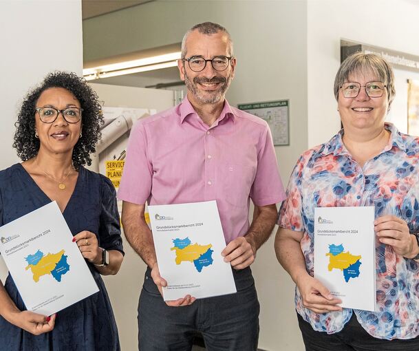 Stellen in bewegten Zeiten den Grundstücksmarktbericht vor: Bouchra Kaplan (links, zuständig für Layout und Redaktionelles), Olaf Dienelt (Vorsitzender des Gutachterausschusses) und Jutta Kittelmann (stellvertretende Ausschussvorsitzende).