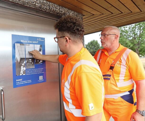 „Muss das sein?“ fragen sich oft auch diese Mitarbeiter, die Rastplatz-WCs reinigen. Und viel Hoffnung in die neuen Plakate setzen.