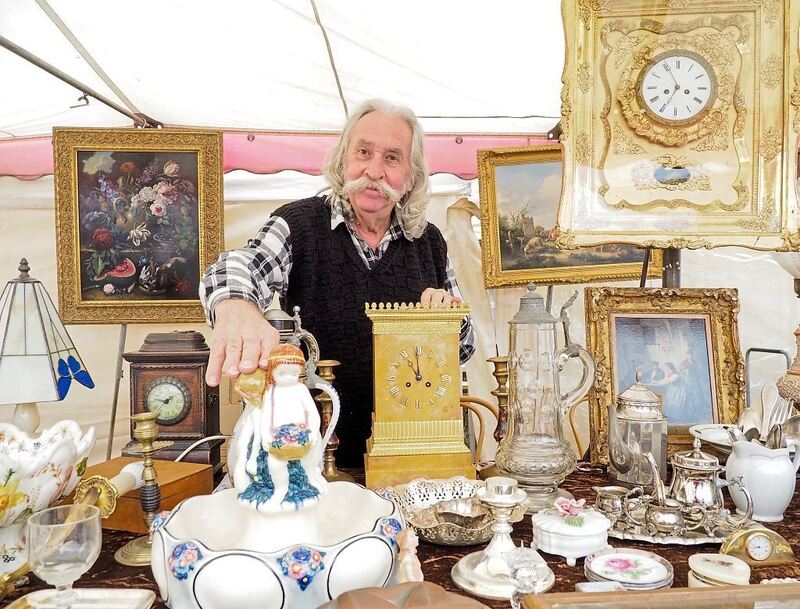 Händler Michael Winkler aus Nürtingen mit Rahmenuhr samt Spielwerk und im Vordergrund eine Majolika aus der Keramikmanufaktur Karlsruhe.