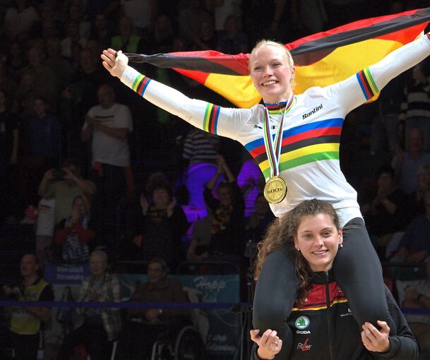 Jubel mit deutscher Fahne, Goldmedaille und im Regenbogen-Trikot: Die entthronte Weltmeisterin Ramona Dandl trägt ihre Nachfolgerin Lara Füller nach der Siegerehrung auf den Schultern.