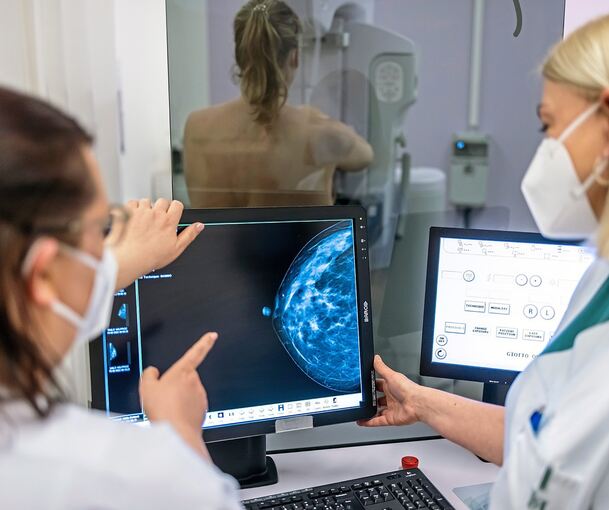 Medizinisches Personal untersucht mit einer Mammografie eine Brust auf Brustkrebs.