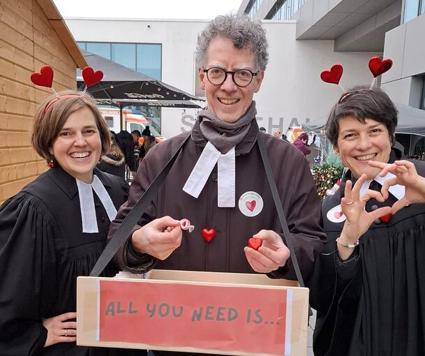 Pfarrerin Isabella Bigl, Pfarrer Timotheus Rölle und Pfarrerin Eva Engelking (von links) verschenken Schokoherzen und Liebe.