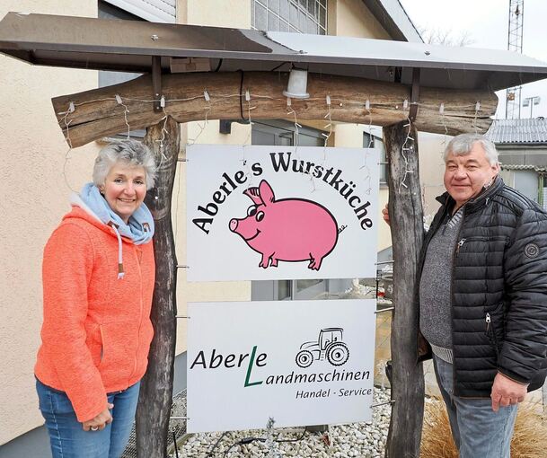 Petra und Werner Aberle vor dem Schild mit ihrem Firmenlogo, dem pinken Schweinchen.