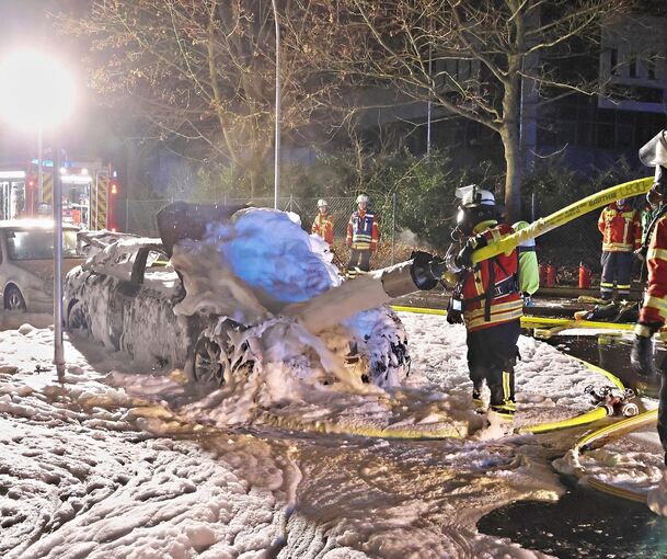 Mit viel Schaum löscht die Feuerwehr das Auto.