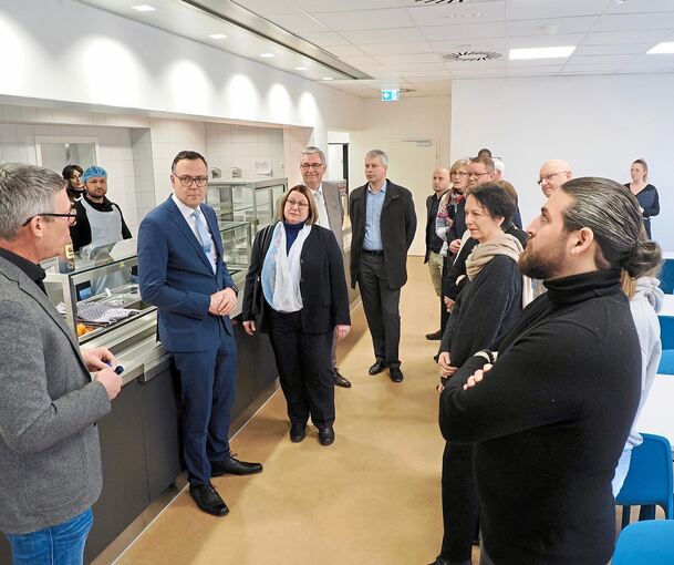 Thomas Deines, Leiter des Referats Flüchtlingsaufnahme und Integrationsförderung des Regierungspräsidiums Stuttgart (links), führt durch die Erstaufnahmeeinrichtung. Daneben im blauen Anzug: Migrationsstaatssekretär Siegfried Lorek. Zweite von rechts