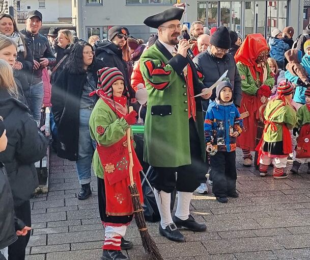 Der Zunftmeister der Mistelhexen, Stefan Diefenbach, umringt von Hexen und Schaulustigen vor dem Rathaus.