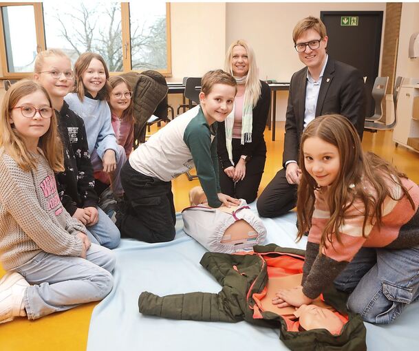 Die angehenden Juniorhelfer Merve, Paula, Sofia, Ronja, Maximilian und Romy zeigen Bürgermeister Markus Kleemann, was sie bei Bettina Kießlich-Steib gelernt haben.