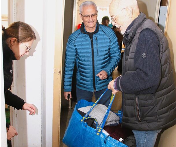 Olaf Büscher (rechts), Leiter des Arbeitskreises Asyl, nimmt Spenden entgegen.