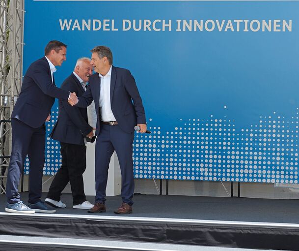 Gratulation vom Minister: Beim Innovationstag Mittelstand 2024 schüttelt Robert Habeck (rechts) die Hand von mm-lab-Geschäftsführer Steffen Firchau. Dahinter ist Michael Meiser, Mitglied der mm-lab-Geschäftsführung, zu sehen.