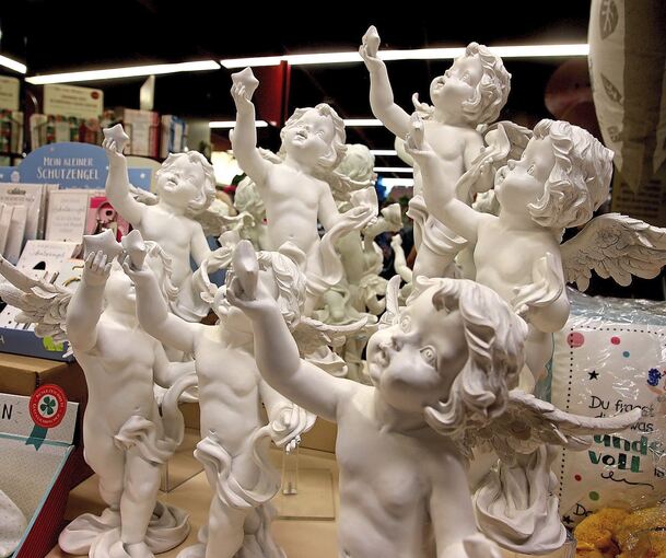 Etwas versteckt stehen kleine Engel im Regal.
