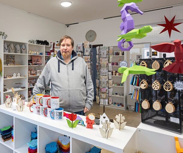 Diego Meier hinter einem Regal mit eigenen Dekoartikel, dahinter sind einige der vermieteten Regalflächen.