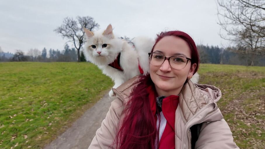 Reiterin mit Katze auf der Schulter unterwegs