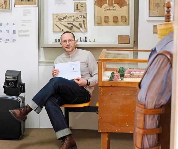 Denis Bury auf einer der gelben Sitzbänke aus Stammheim im Ludwigsburger Strafvollzugsmuseum.