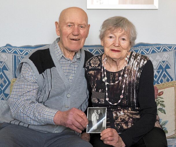 Ella und Robert Huber halten ein Hochzeitsfoto in den Händen. Vor 70 Jahren wurde das aufgenommen. So lange sind sie verheiratet.