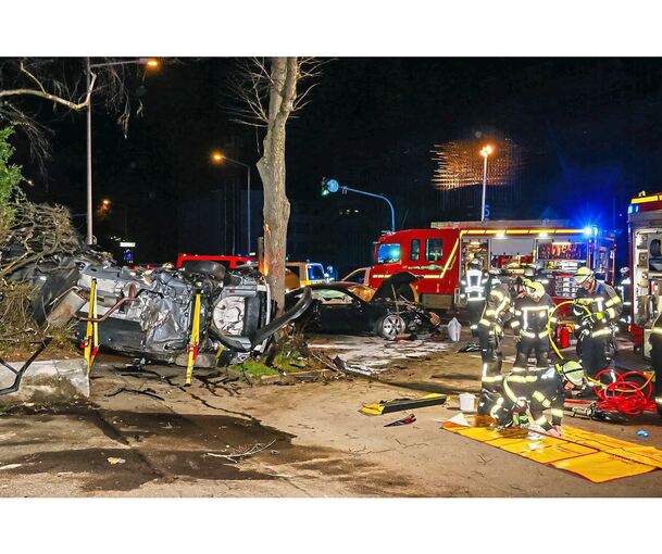 Der eine Wagen liegt nahezu völlig zerstört auf der Seite am Straßenrand, der andere ist lediglich beschädigt.
