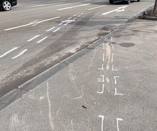 Auf der Straße sind die Markierungen der Polizei deutlich sichtbar.