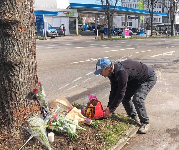 Am Morgen nach dem Unfall legen Menschen Blumen nieder und zünden Kerzen an.