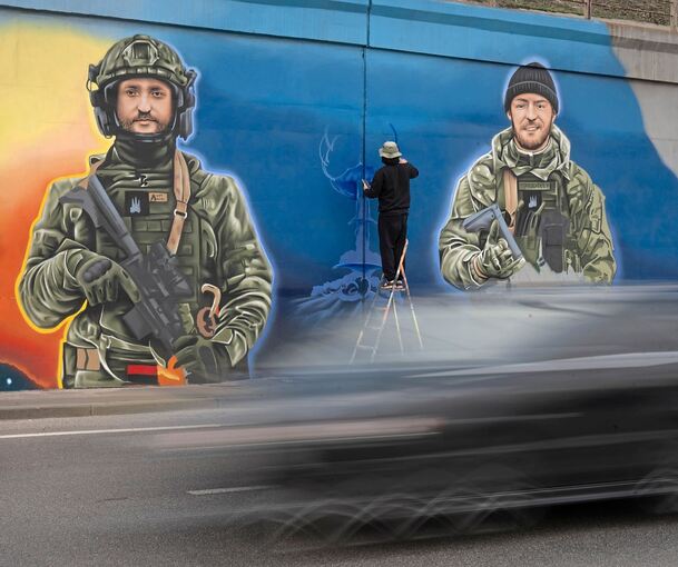 Ein Künstler arbeitet in Kiew an einem Wandgemälde, das den freiwilligen Soldaten gewidmet ist, die im Krieg gegen Russland gefallen sind.