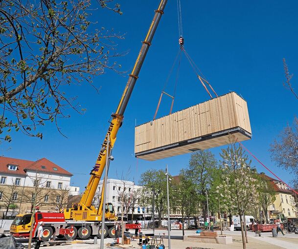 Mit einem Kran wird der zwölf Tonnen schwere Pavillon auf den Zentimeter genau platziert.