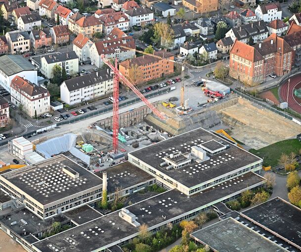 Die Zeit der Kräne am Bildungszentrum West hat begonnen: Die Baugrube neben Otto-Hahn-Gymnasium und Gottlieb-Daimler-Realschule (linker Teil) ist ausgehoben, jetzt starten die Rohbauarbeiten. Dem Turmkran soll bald ein zweiter folgen.