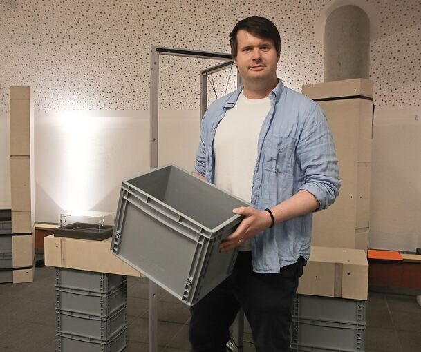 Kurator Alexander Schwanebeck zeigt einer der grauen Industrieboxen, in denen er und seine Kollegen die Ausstellungsobjekte gesammelt haben.