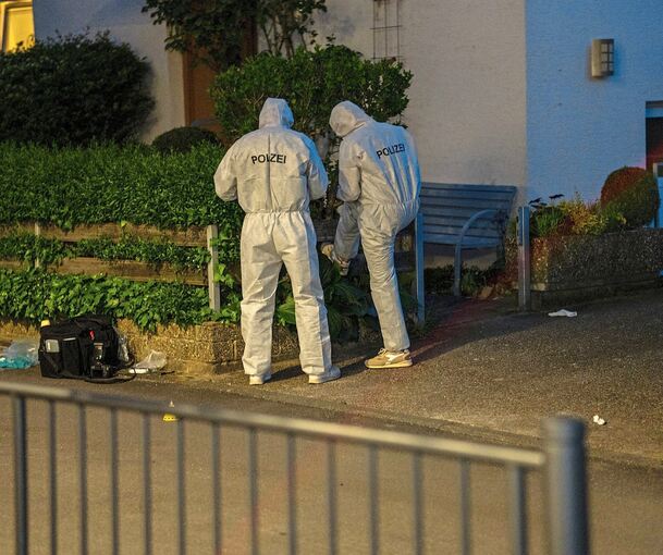 Einsatzkräfte der Polizei sichern nach der Schießerei in Tamm Spuren.
