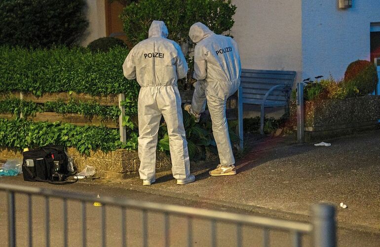 Einsatzkräfte der Polizei sichern nach der Schießerei in Tamm Spuren.