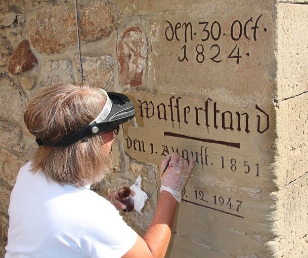 Feiner Pinselstrich und ruhige Hand: Carmen Diehl bei der Arbeit an den Hochwassermarken in der Auricher Straße.