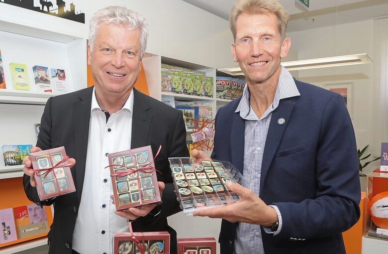 Oberbürgermeister Jürgen Kessing (links) nimmt die neu kreierten Stadtpralinen von Confiseur Eberhard Blatter entgegen.