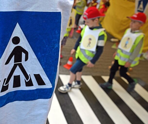 Kinder gehen über einen Zebrastreifen.